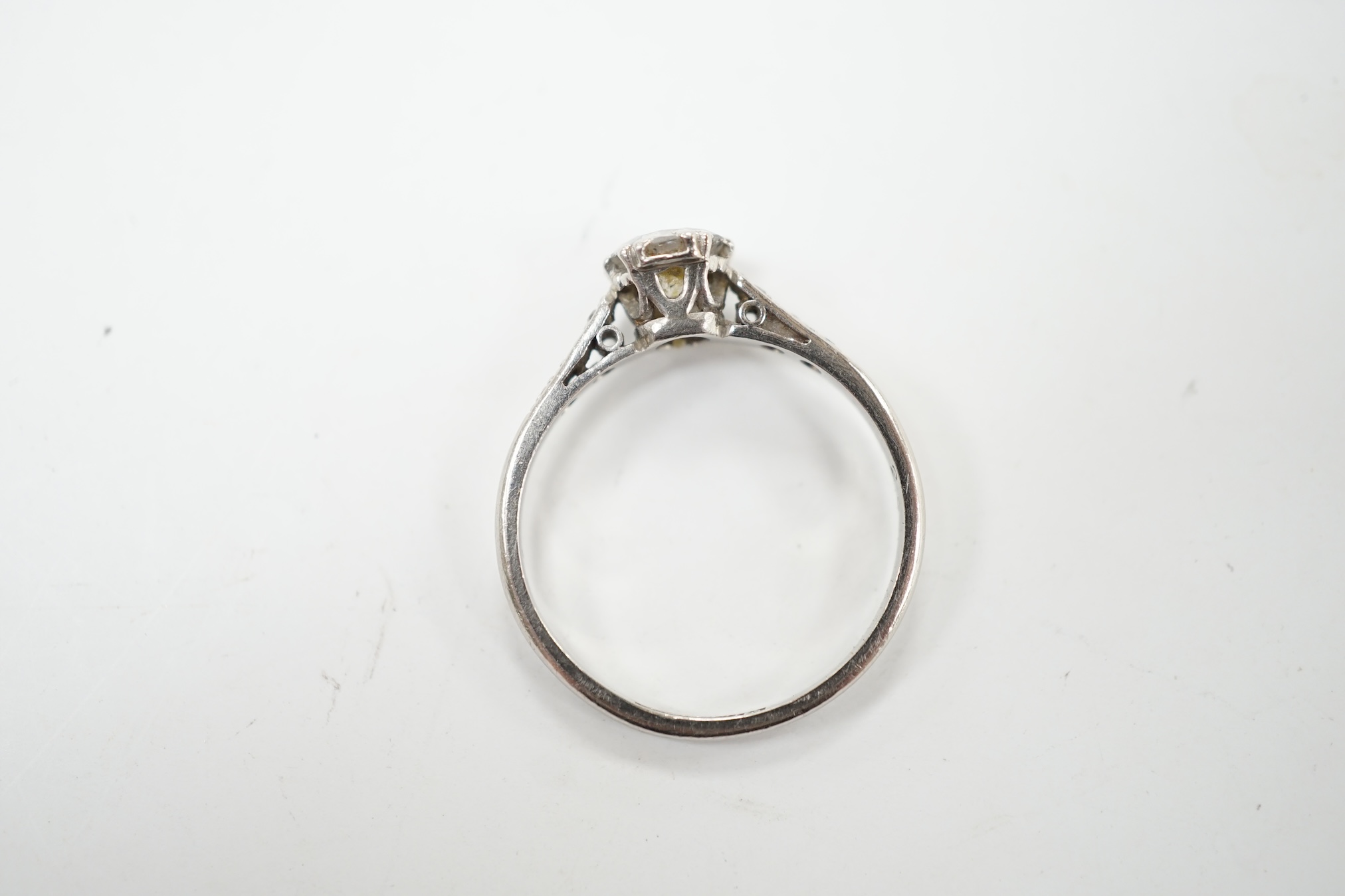 An early to mid 20th century white metal (stamped platinum) and single stone diamond set ring, with six stone diamond chip set shoulders, the stone diameter 5.5mm, depth 3mm, size N, gross weight 2.7 grams. Condition - f